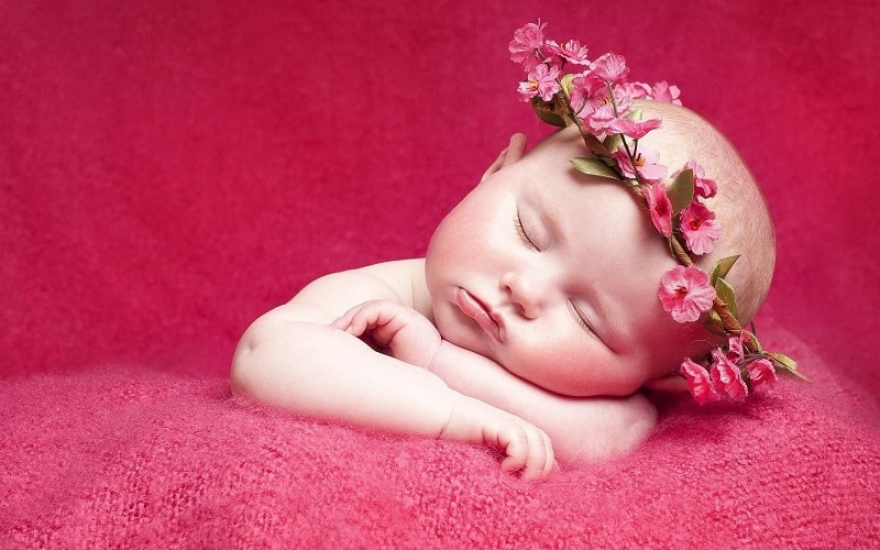 baby girl sleeping while wearing a flower crown