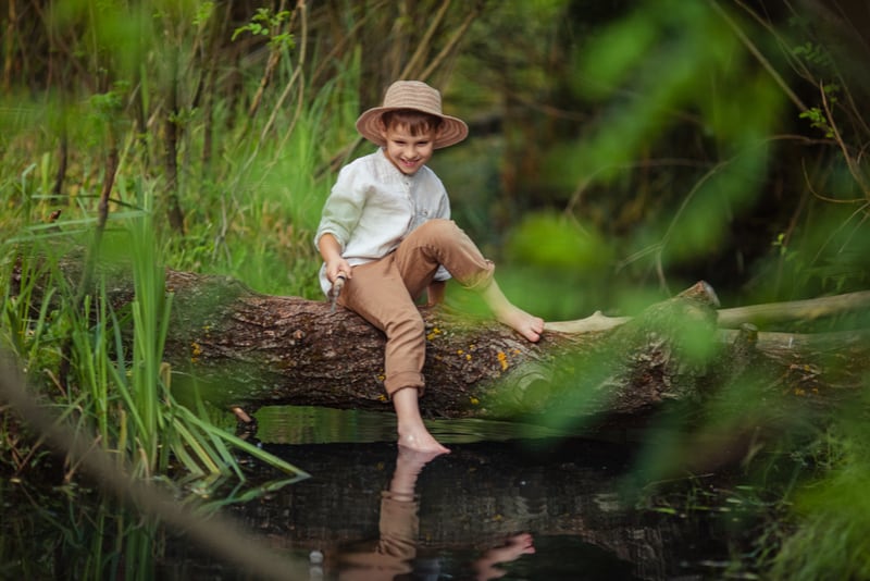 boy in rustic clothes and wicker hat 