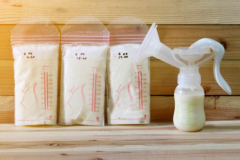 breast pump with storage breast milk in bags on the table