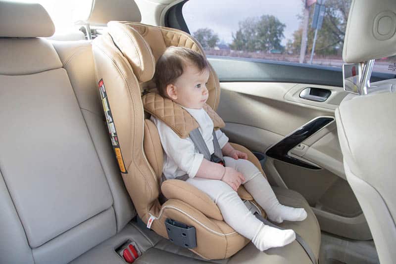 cute baby girl sitting in a car seat