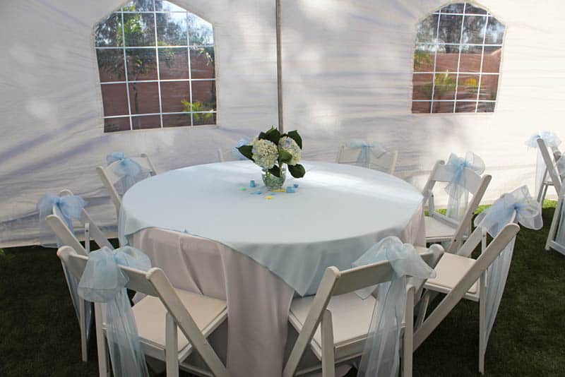 decorated table with chairs in a white tent