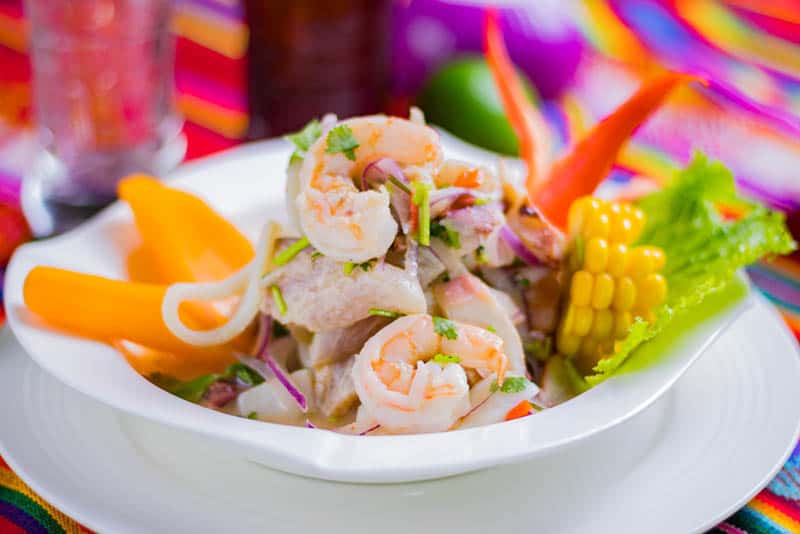 fish ceviche served with vegetables on plate