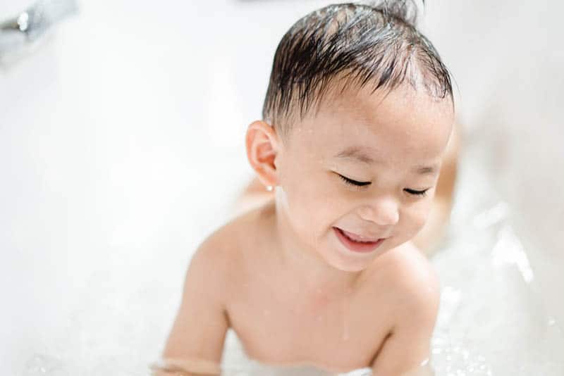 happy toddler having a bath in bathtube