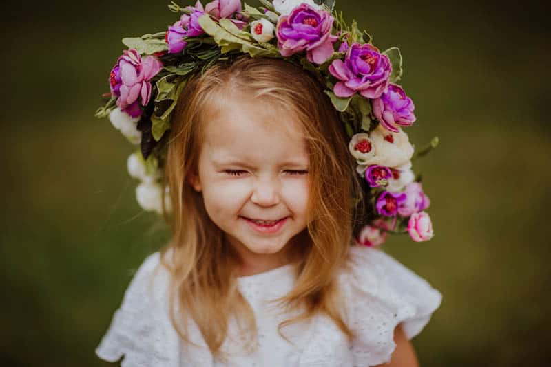 little girl smiling with flowers on the head