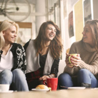 a group of female friends having fun while talking in a coffee shop