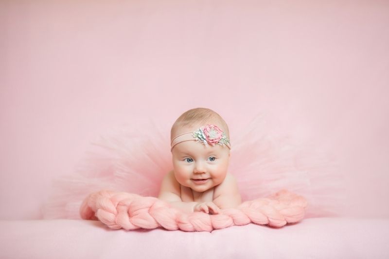cute baby girl in a pink dress smiling