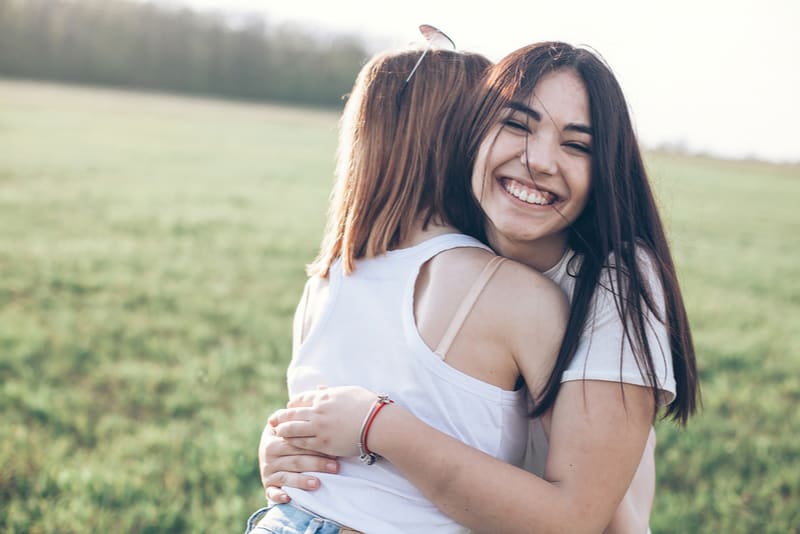 Two young women hugging outdoors