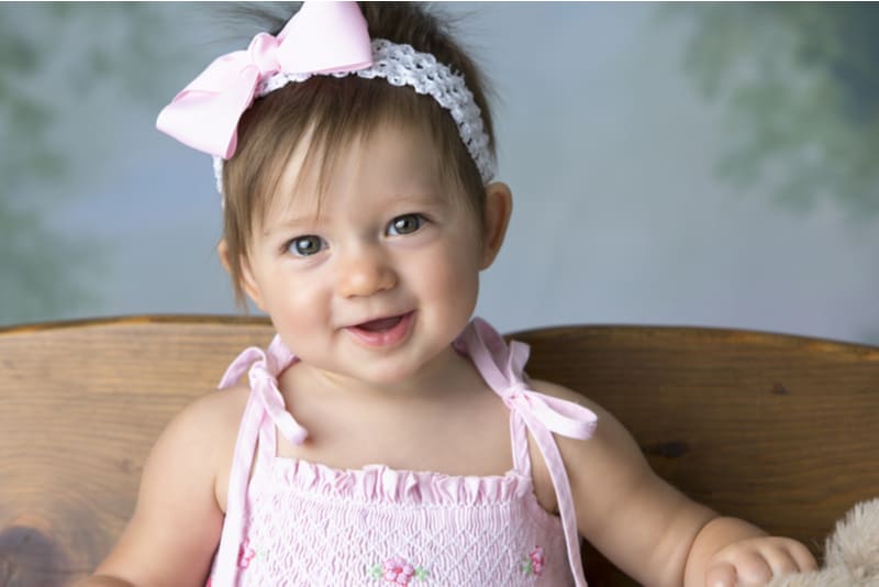baby girl with bow in hair smiling