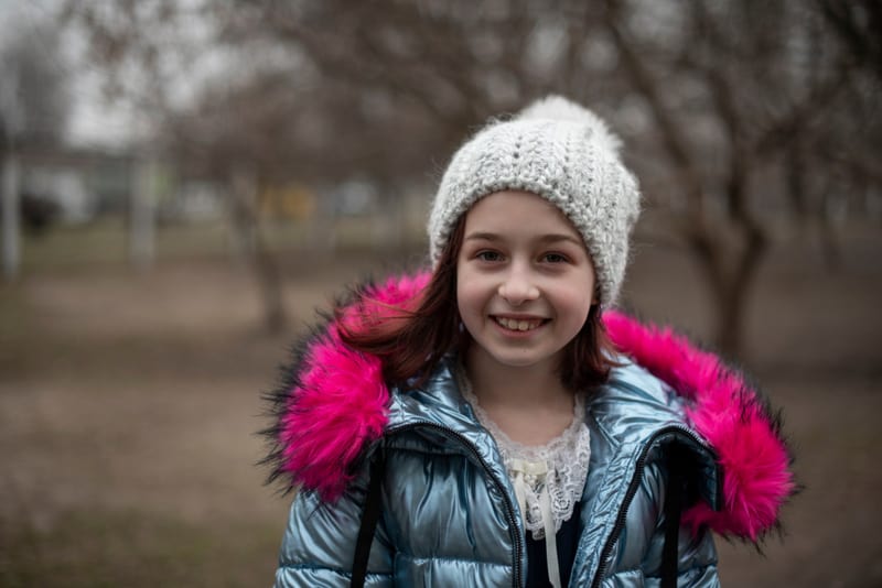 beautiful little girl wearing jacket in park