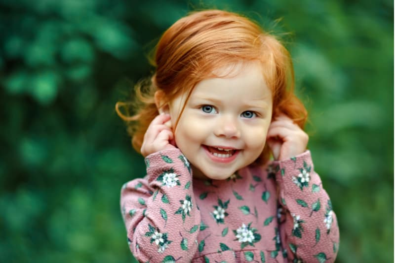 beautiful red-haired little girl smiling happily