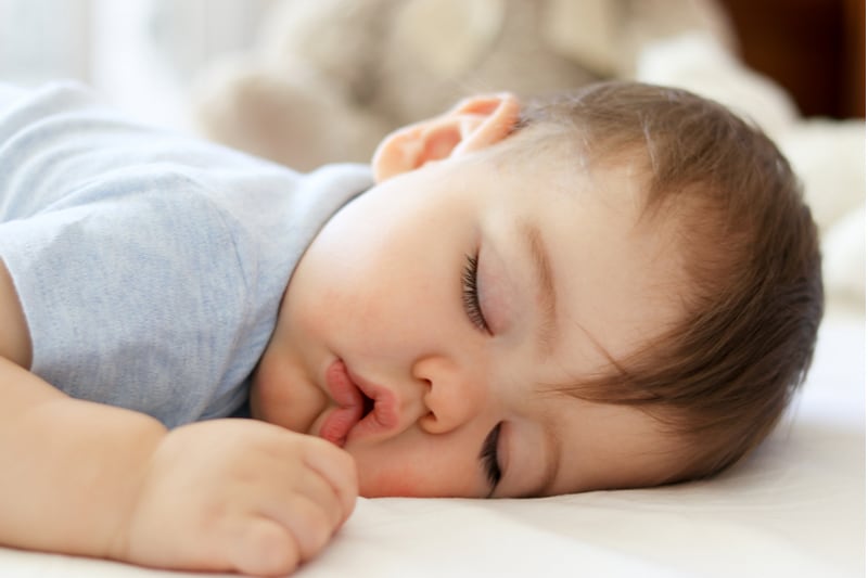 little baby sleeping on stomach with funny open mouth