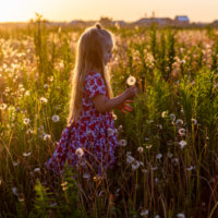 little girl with very long blonde straight hair in a floral dress