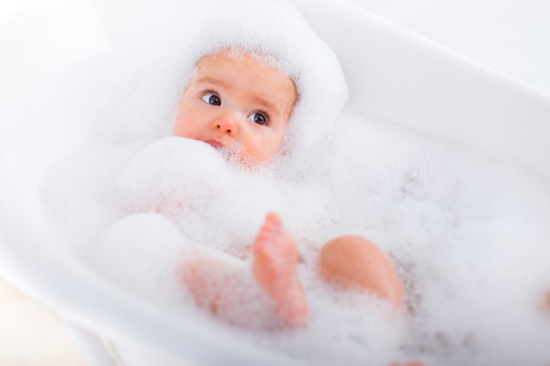 Baby in a plastic tub full of foam