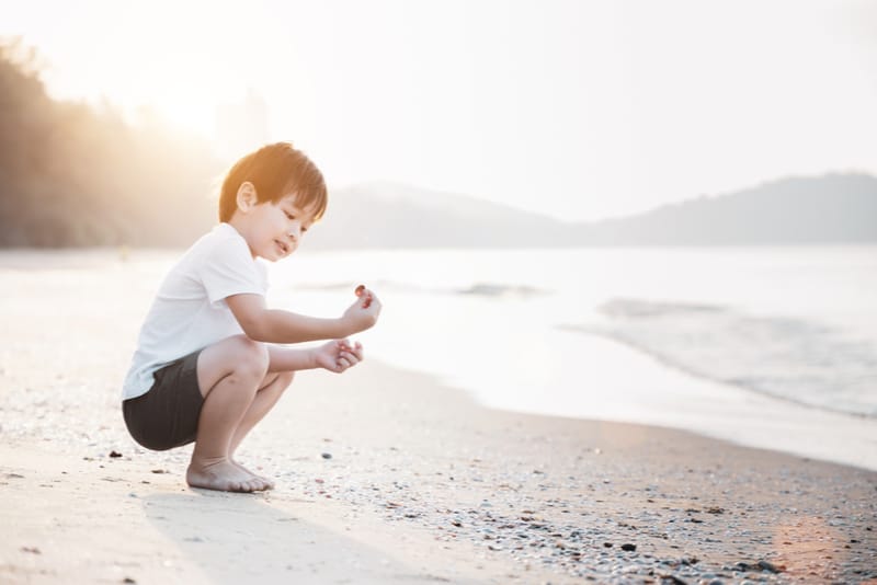 Boy playing on the beach on a summer holiday