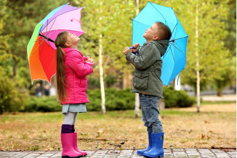 Cute children with umbrellas in park