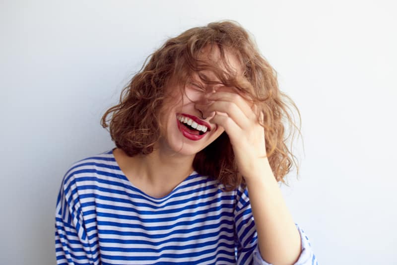 Laughing woman in marine shirt with curly hair 