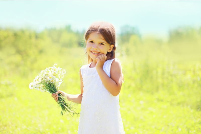 happy smiling little girl with flowers