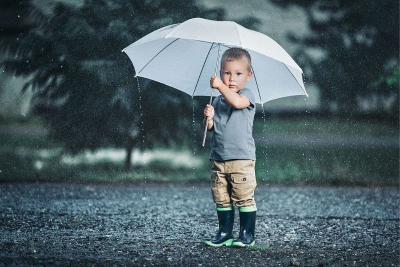 little boy outdoors holding umbrella