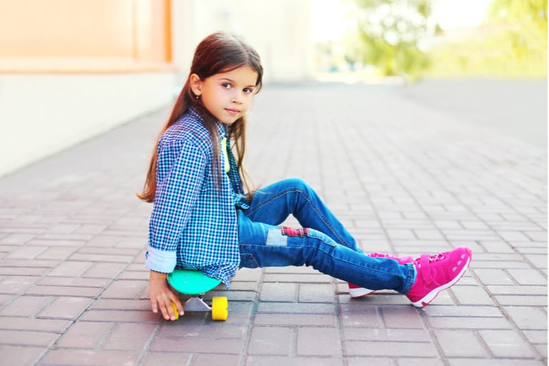 little girl child sitting on skateboard