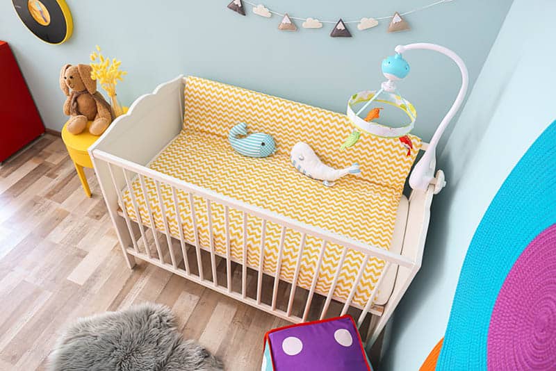 baby crib with toys and baby items in the bedroom