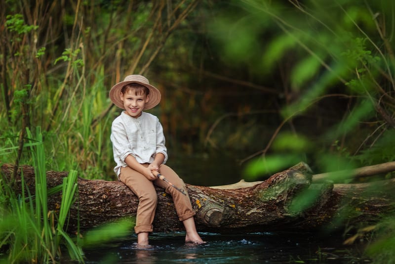 boy in rustic clothes and wicker hat