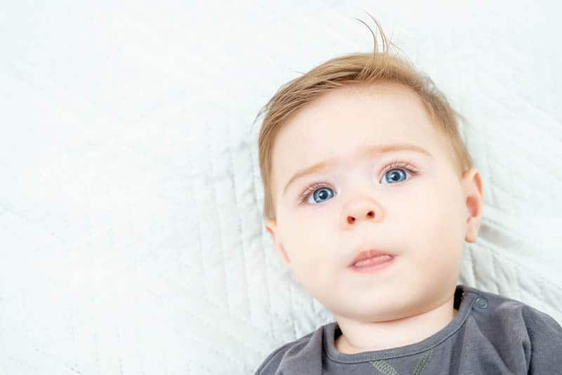 cute baby boy with beautiful blue eyes looking at camera