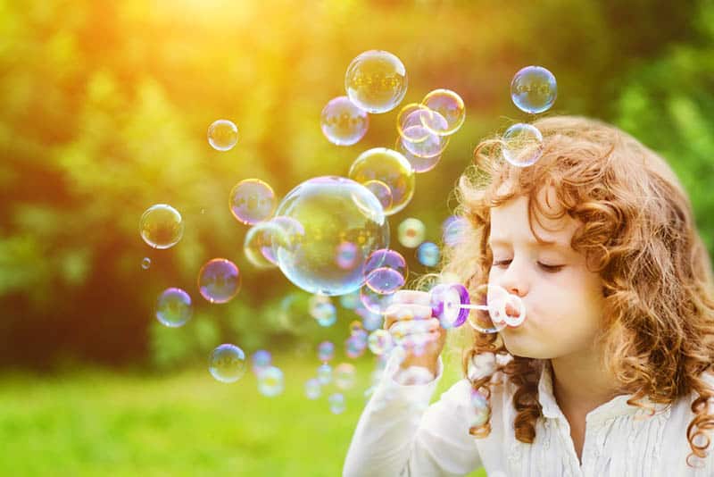 cute girl playing with bubbles