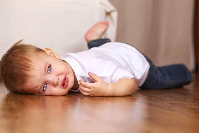 cute little boy with blue eyes lying on the floor
