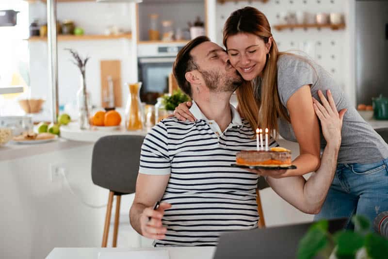 husband kissing his wife for a birthday surprise