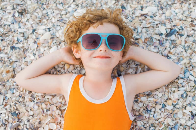 little curly-headed boy with blue sunglasses