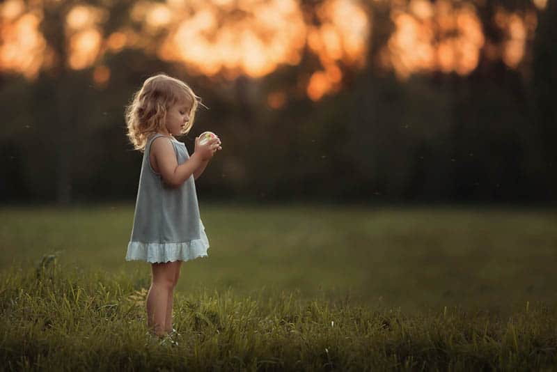 little girl playing with ball in the field