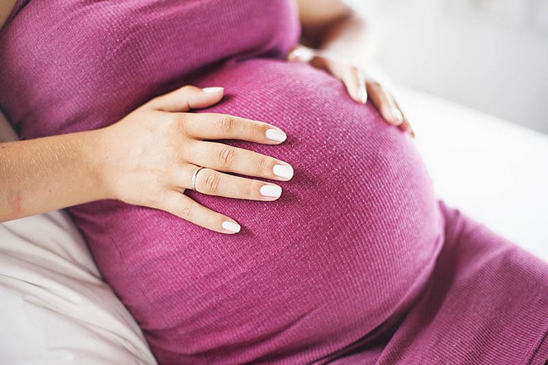 pregnant woman holding hands on the belly