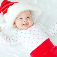 adorable baby smiling in Santa Claus suit