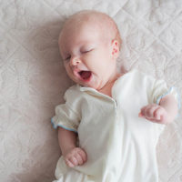 cute baby boy yawning on the bed