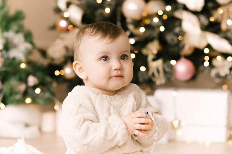 Little cute baby girl under the Christmas tree