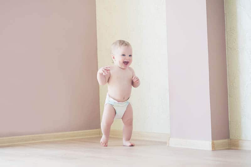 cute baby boy in diaper walking at home