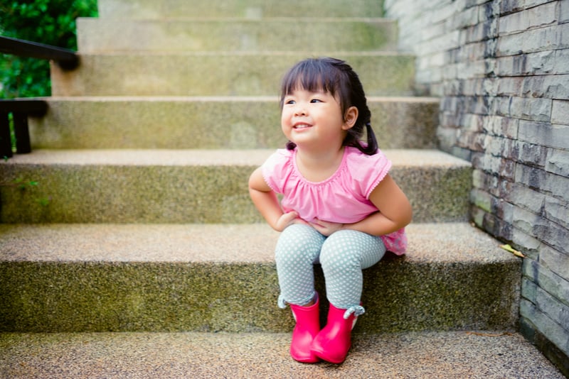 cute little asian girl sitting on the stairs