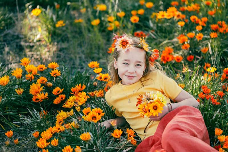 little girl posing in a meadow with flowers