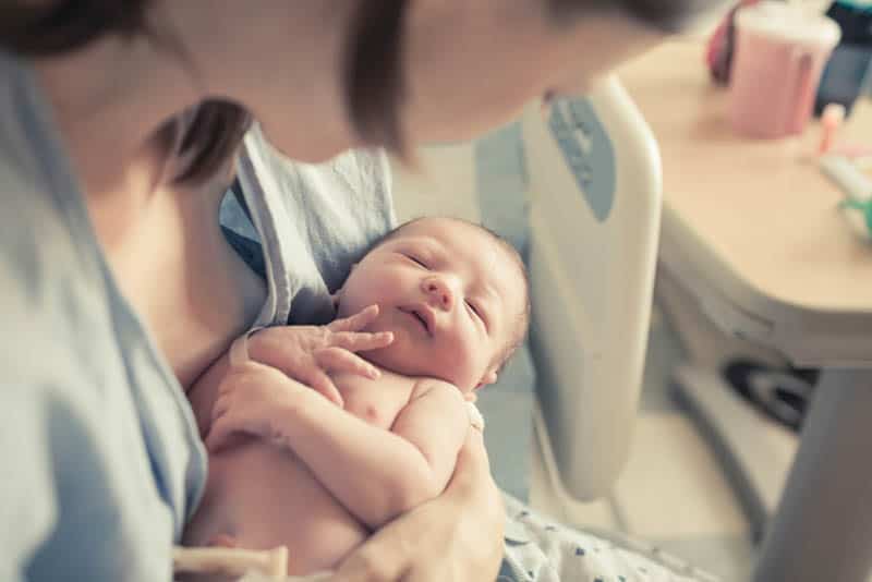 young mother holding a newborn baby in hands