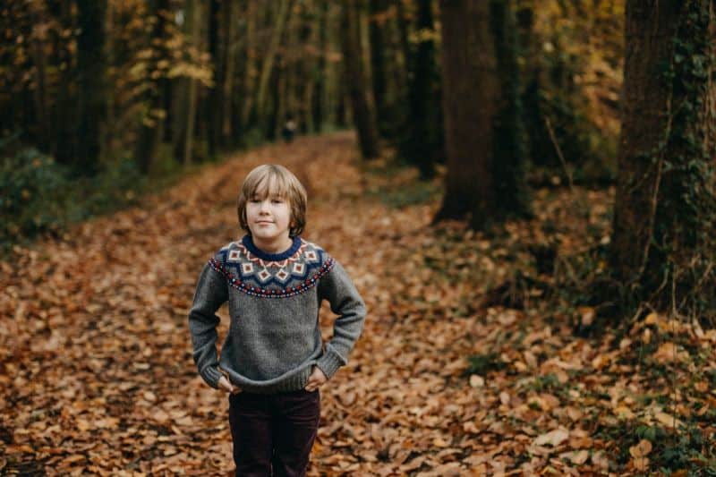 boy in a sweater in a forest